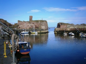 Sundart secured against the wall at low tide at Dunbar. The harbour entrance is to the right - blasted a hundred years ago through the rock and old castle walls. The kittiwakes were nesting in the castle wall above Sundart.